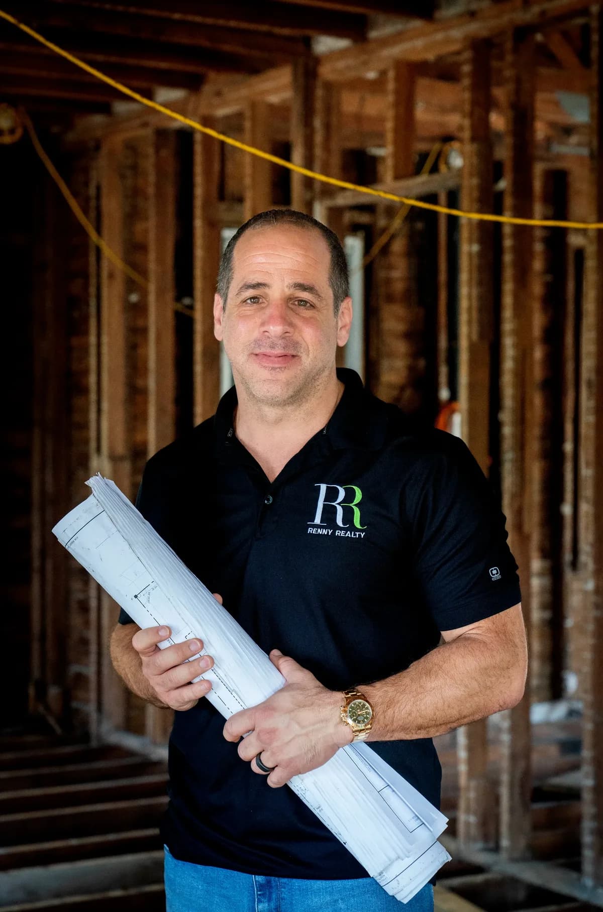 Gus Renny on a job site, holding the plans